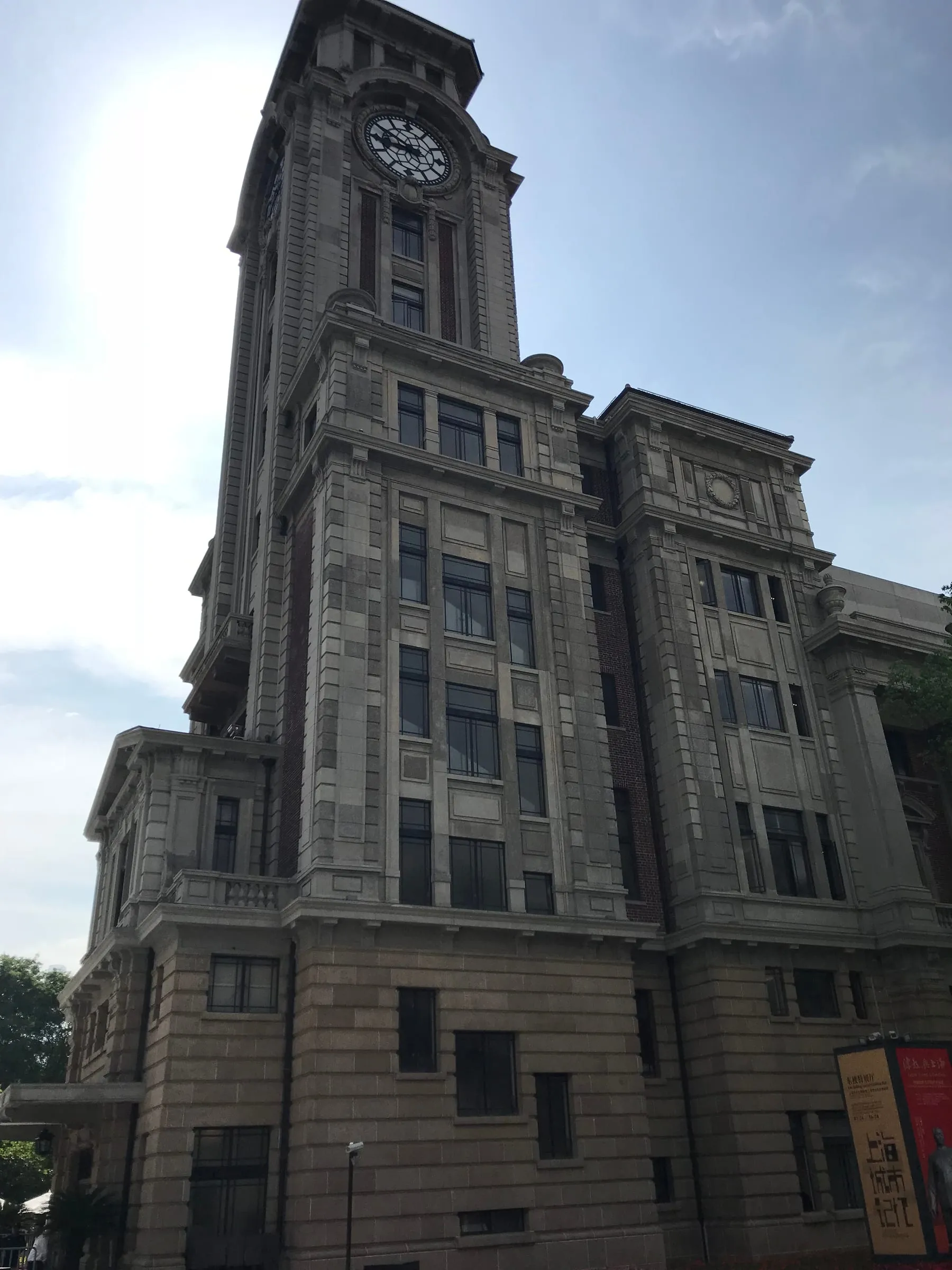 A tall stone clock tower seen from below, against a morning sky