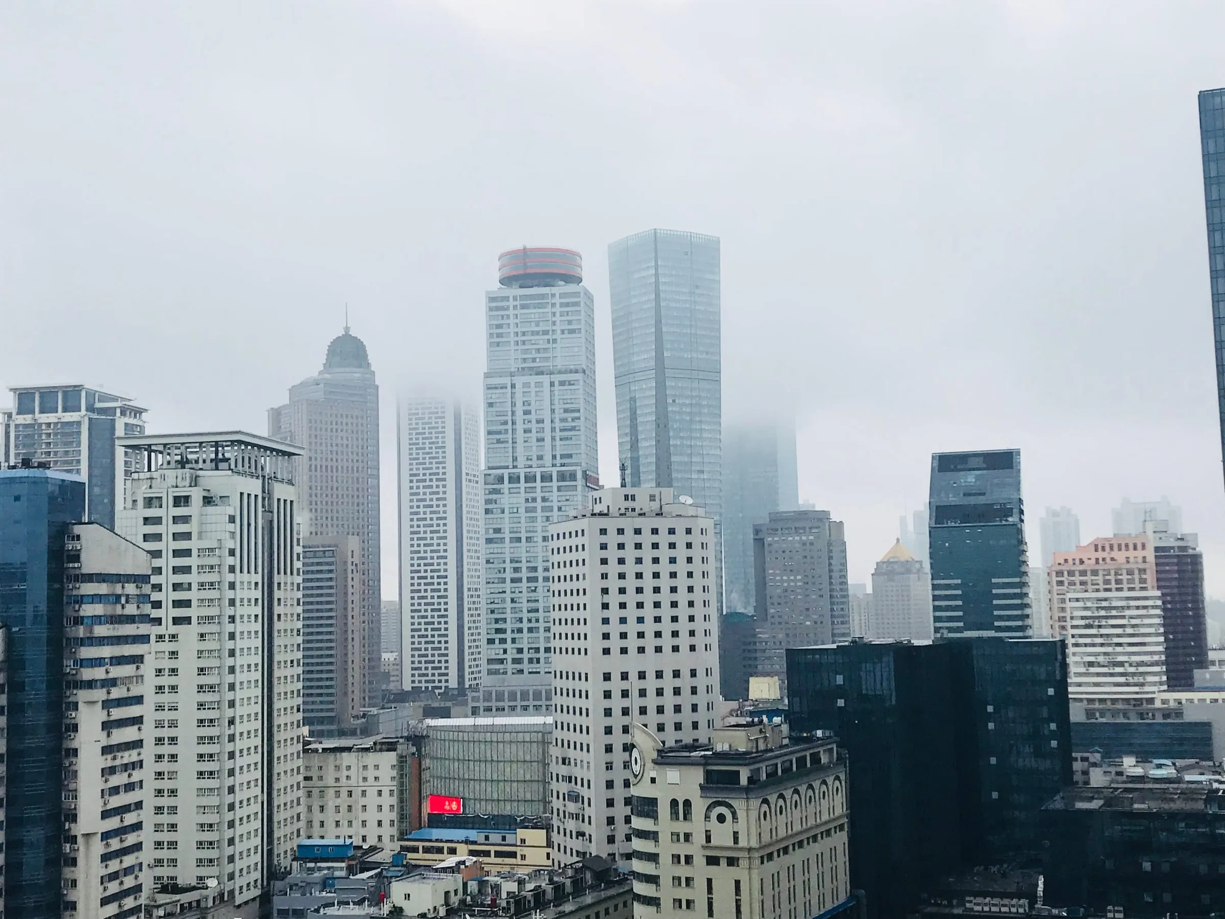 A dense cluster of office towers fading into mist